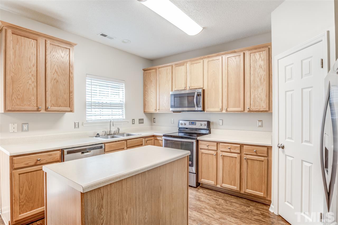 105 Watertree Lane Apex, NC 27502 - Photo 13 of 30 a kitchen with a sink stove top oven and refrigerator