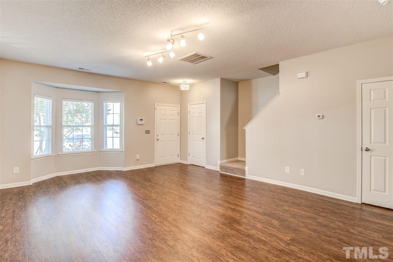 105 Watertree Lane Apex, NC 27502 - Photo 5 of 30 an empty room with wooden floor and windows