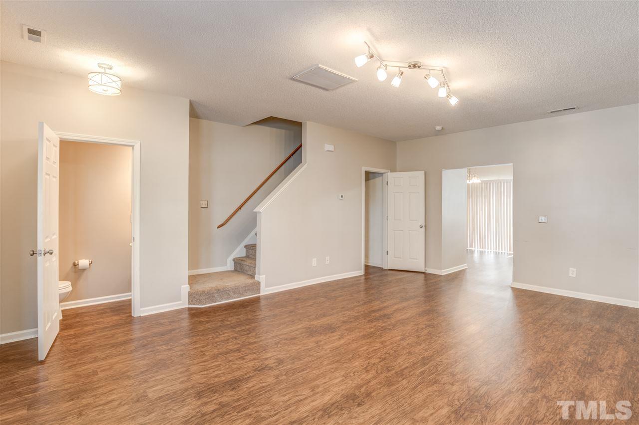 105 Watertree Lane Apex, NC 27502 - Photo 7 of 30 a view of an empty room with wooden floor and a bathroom