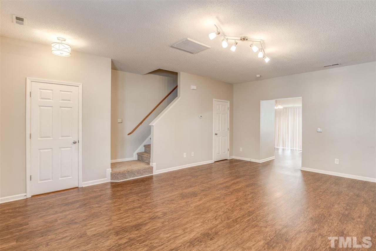 105 Watertree Lane Apex, NC 27502 - Photo 8 of 30 a view of an empty room with wooden floor and a ceiling fan