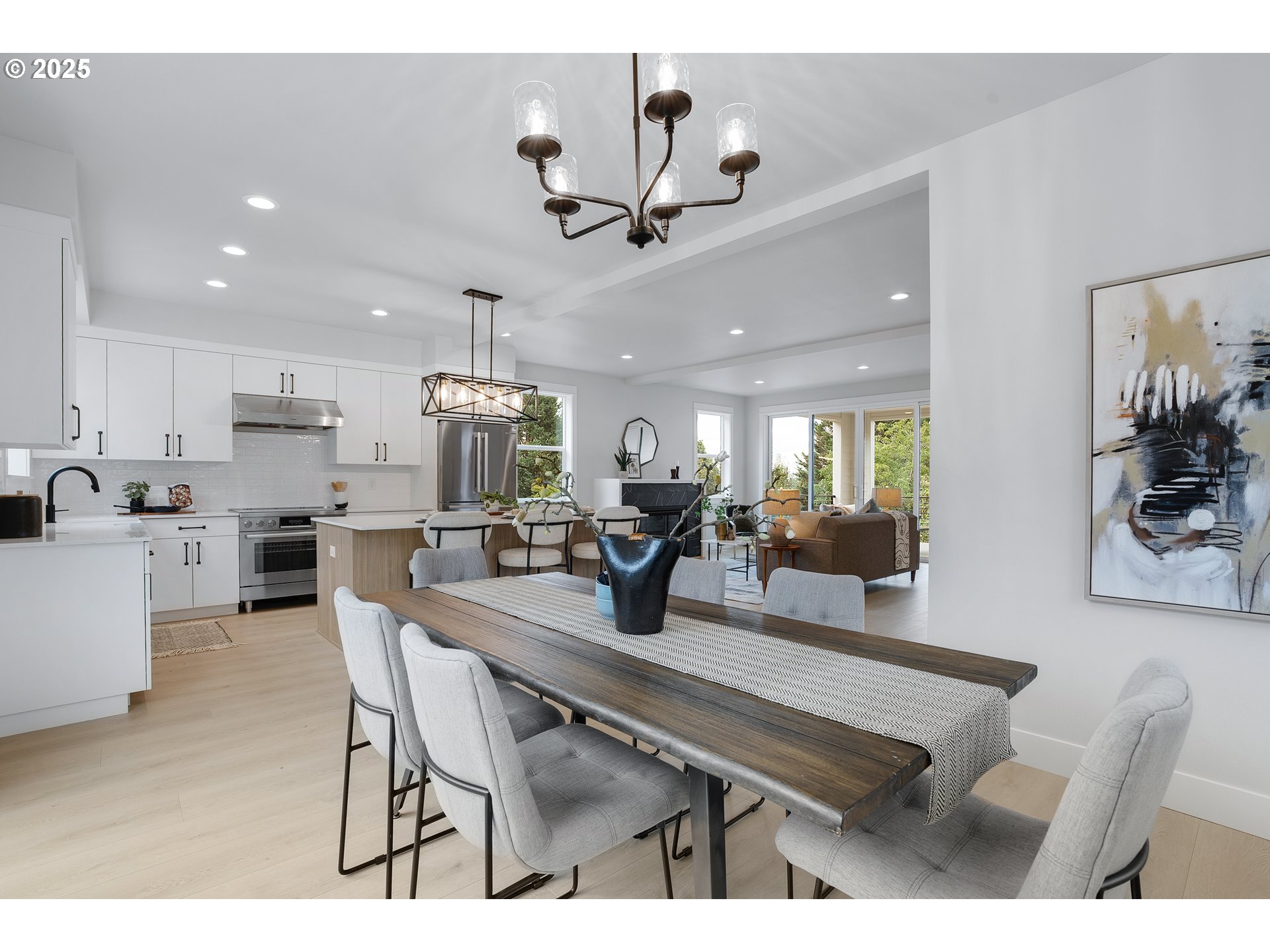 6024 Southwest 18th Drive Portland, OR 97239 - Photo 13 of 46 a kitchen with a dining table chairs stainless steel appliances and cabinets