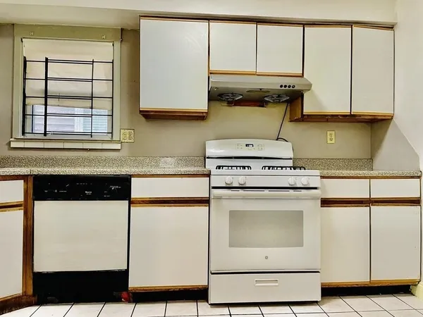 a kitchen with stainless steel appliances granite countertop a stove a sink and white cabinets