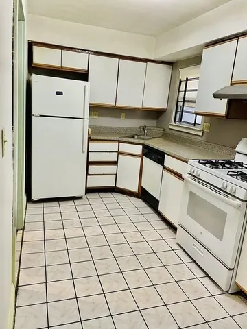 a kitchen with stainless steel appliances cabinets and a stove top oven