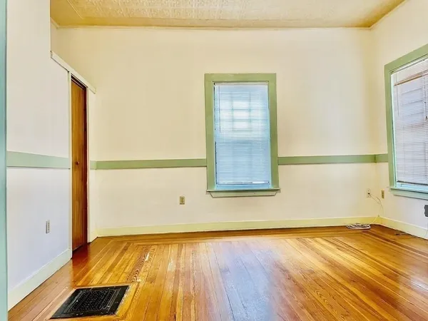 a view of a room with wooden floor and door