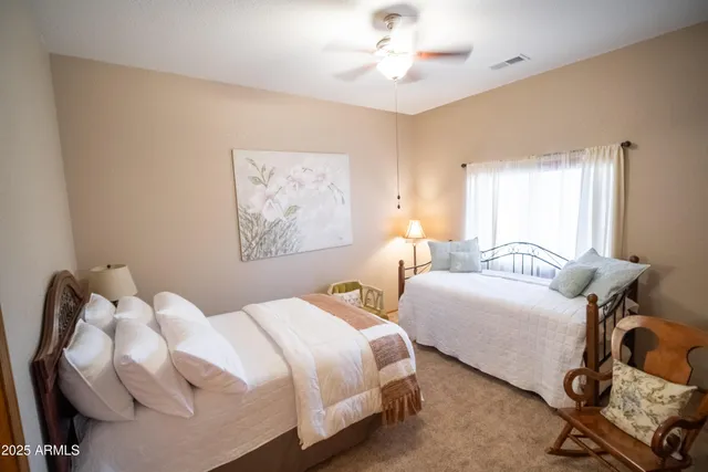 a bedroom with two beds and painting on the wall