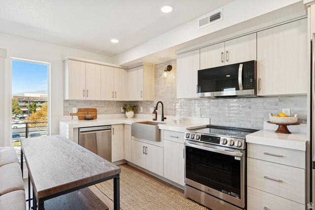 51 East 200 North, Unit 3 Bountiful, UT 84010 - Photo 9 of 27 Kitchen featuring stainless steel appliances, tasteful backsplash, recessed lighting, light stone counters, and light wood-type flooring