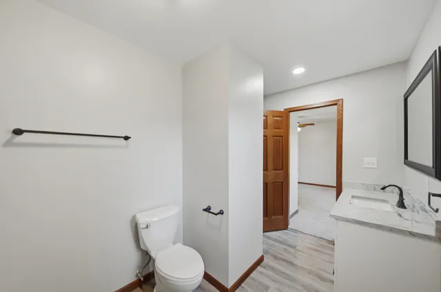 a bathroom with a granite countertop sink toilet a shower and a mirror