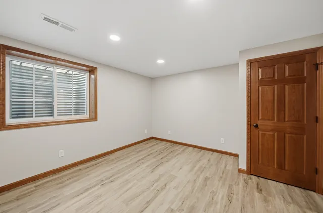 a view of an empty room with wooden floor