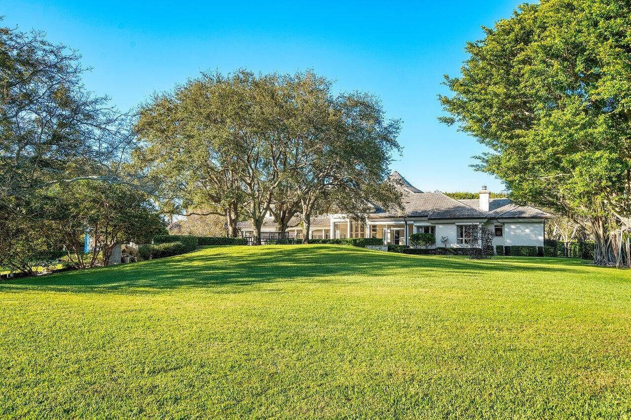 6024 Le Lac Road Boca Raton, FL 33496 - Photo 31 of 37 a view of a house with a big yard and palm trees