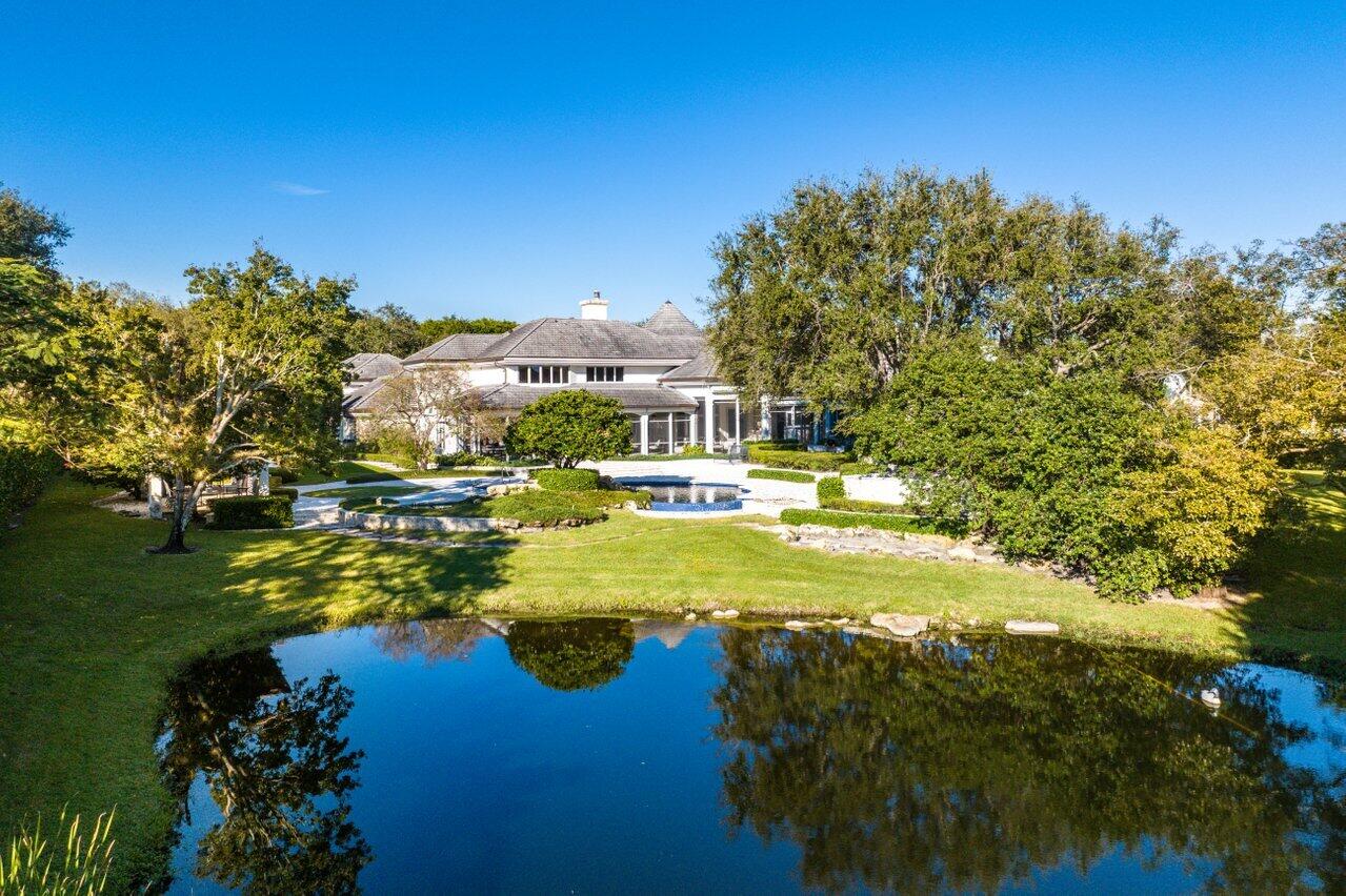 6024 Le Lac Road Boca Raton, FL 33496 - Photo 34 of 37 a view of a house with swimming pool and trees in the background