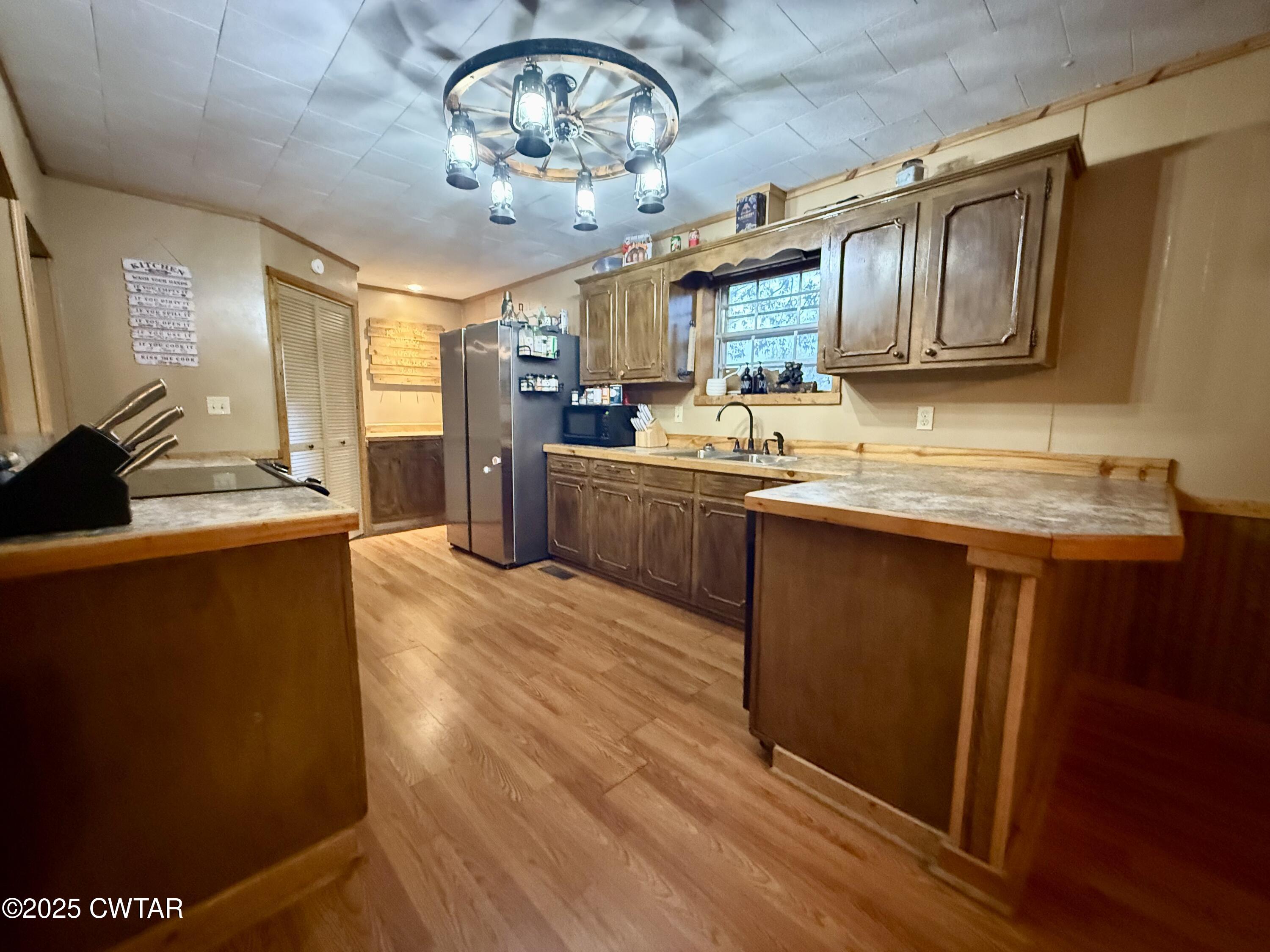 5264 Hines Gin Road Selmer, TN 38375 - Photo 2 of 19 a kitchen with stainless steel appliances granite countertop a sink dishwasher stove and wooden cabinets