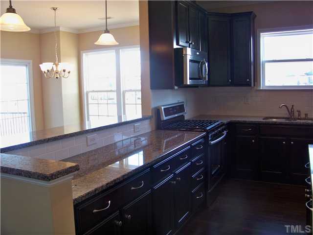 9132 Wooden Road, Unit 261 Raleigh, NC 27617 - Photo 13 of 23 Kitchen features Granite Countertops, Subway Tile Backsplash, Whirlpool Stainless Appliances incl 5 Burner Gas Range/Convection Oven, Kona Cabinetry w/ Knobs & Drawer Pulls, Hardwoods...AND you even get a window over your deep double bowl undermount sInk!