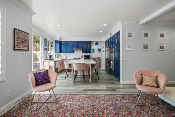 a kitchen with kitchen island granite countertop a refrigerator stove and wooden cabinets