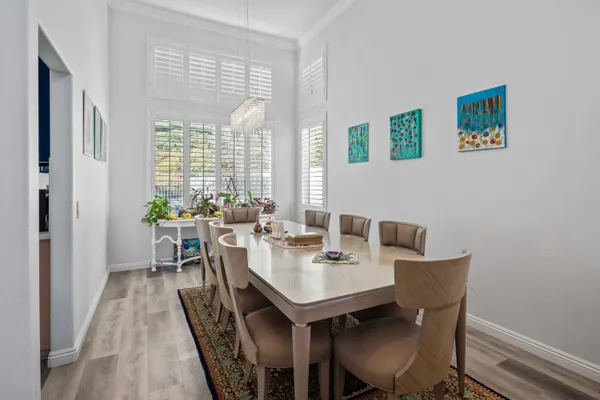 a kitchen with stainless steel appliances granite countertop a table chairs sink refrigerator and cabinets