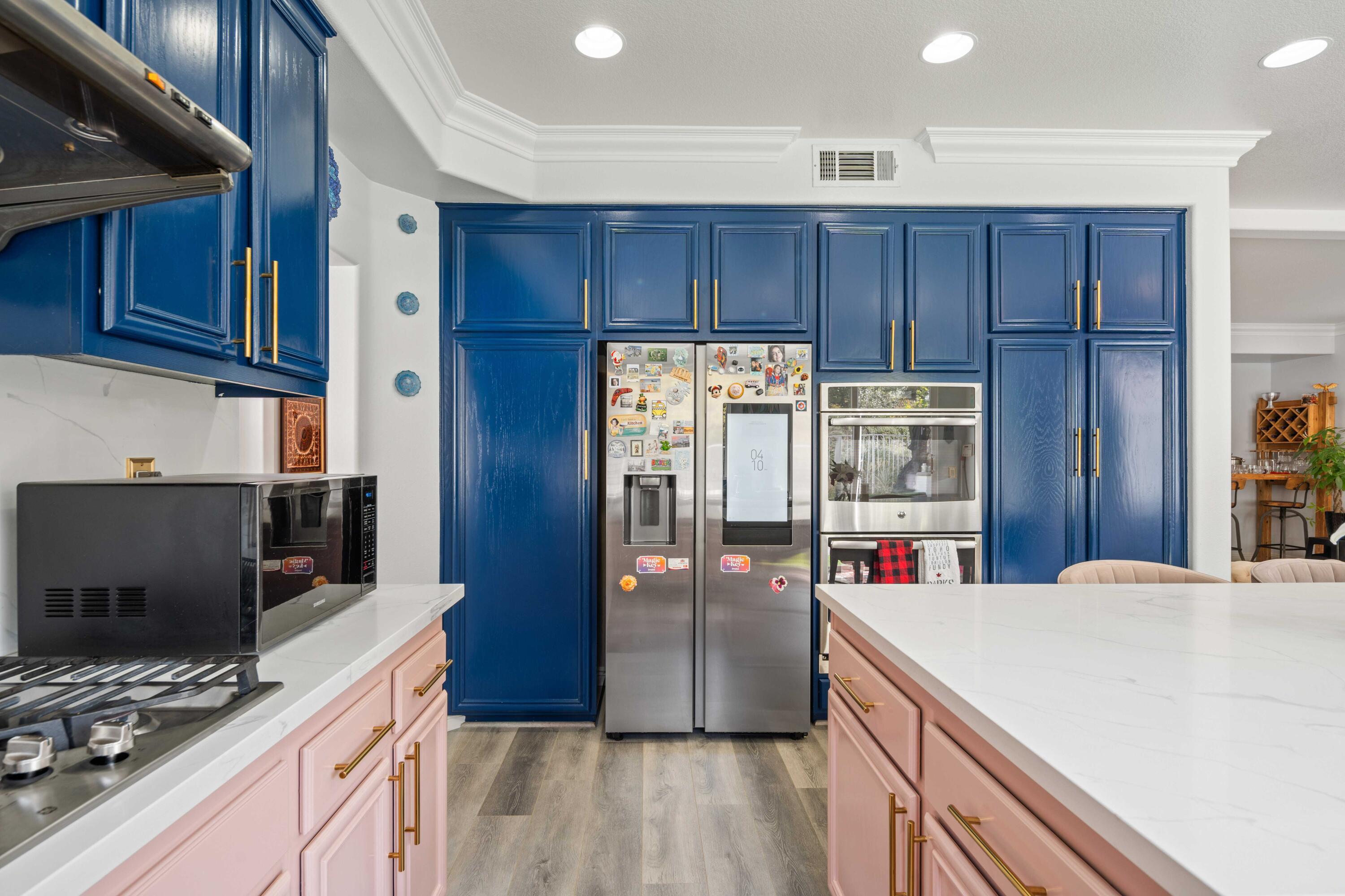 26089 Salinger Lane Stevenson Ranch, CA 91381 - Photo 18 of 47 a kitchen with kitchen island granite countertop a refrigerator stove and wooden cabinets