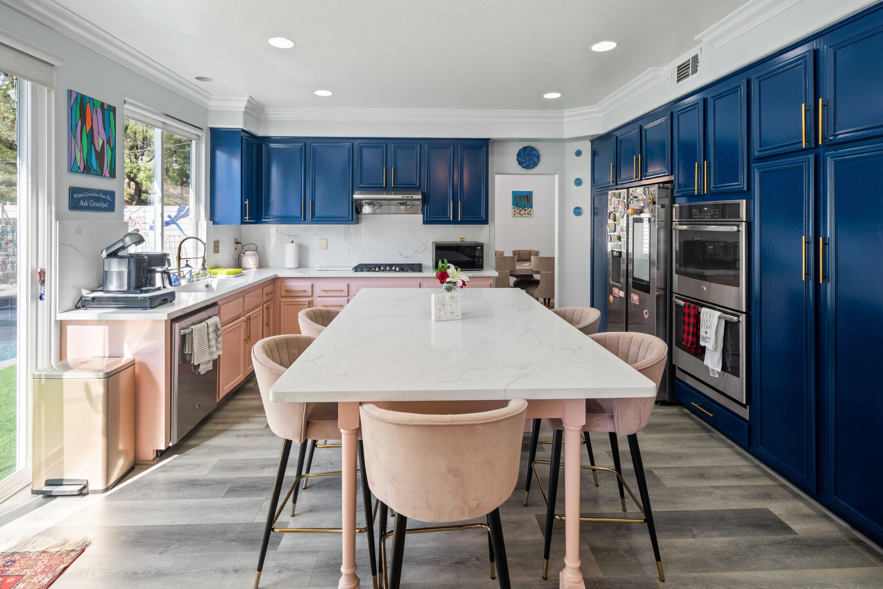 26089 Salinger Lane Stevenson Ranch, CA 91381 - Photo 22 of 47 a kitchen with stainless steel appliances granite countertop a table chairs sink refrigerator and cabinets