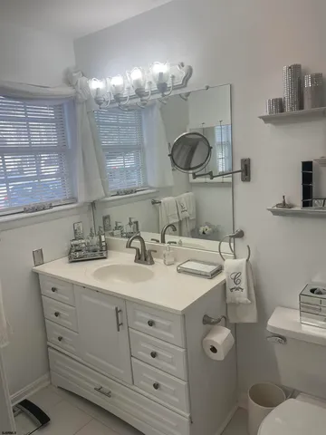 a bathroom with a toilet a double vanity sink and a mirror