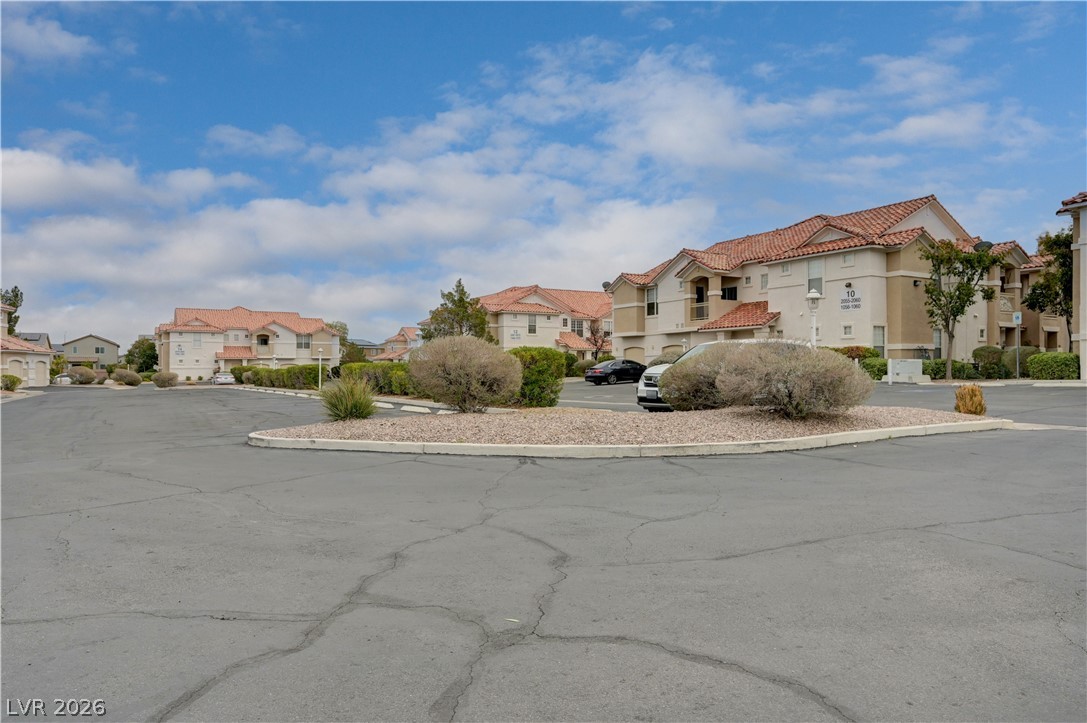 8555 West Russell Road, Unit 1017 Las Vegas, NV 89113 - Photo 17 of 34 A community of stucco residences with tiled roofs offers a harmonious aesthetic under an open sky.