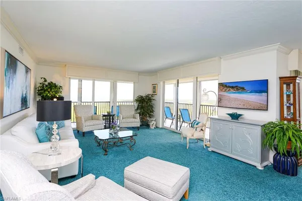 a living room with patio furniture and a floor to ceiling window