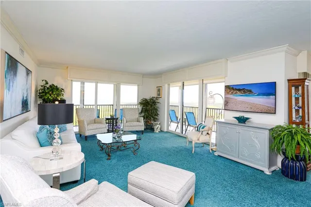 a living room with patio furniture and a floor to ceiling window