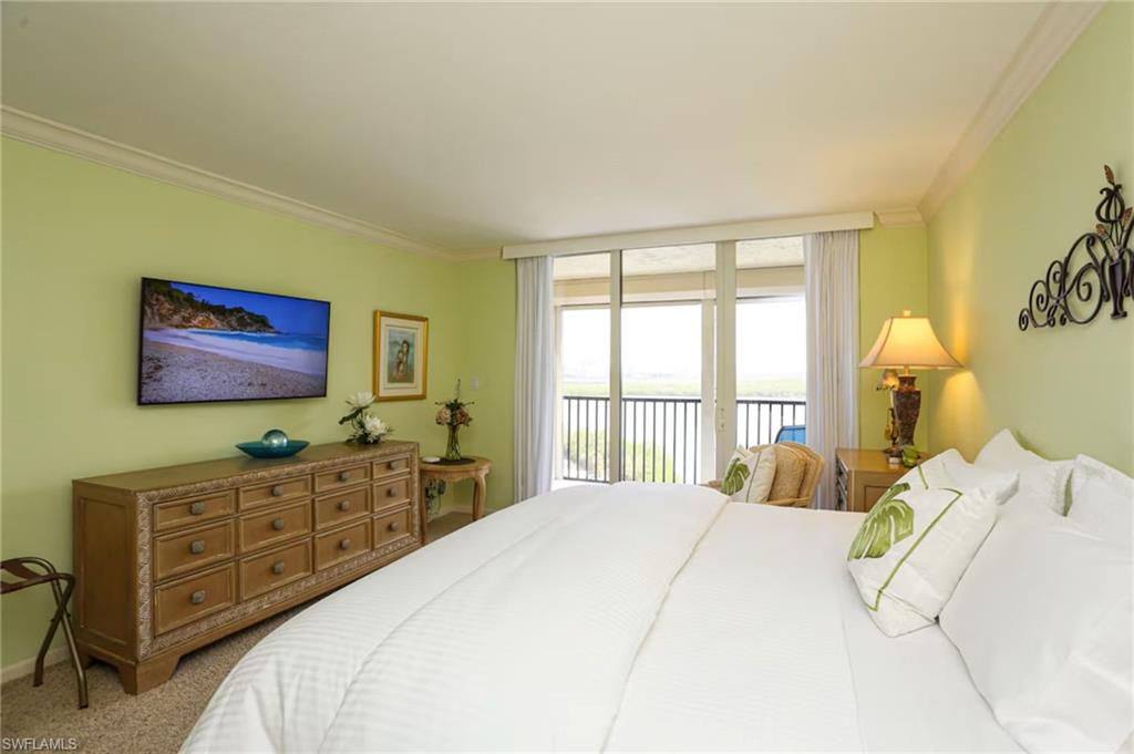 15 Bluebill Avenue, Unit 805 Naples, FL 34108 - Photo 5 of 29 a bedroom with a bed and a flat screen tv