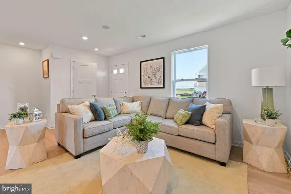 a living room with furniture white walls and a lamp