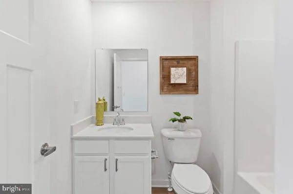 a bathroom with a toilet a sink a mirror and vanity