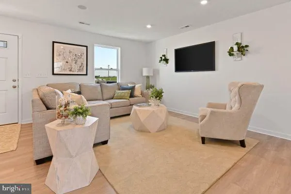 a living room with furniture a flat screen tv and wall paintings