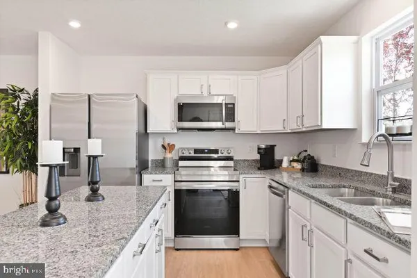 a kitchen with stainless steel appliances granite countertop a sink stove and microwave