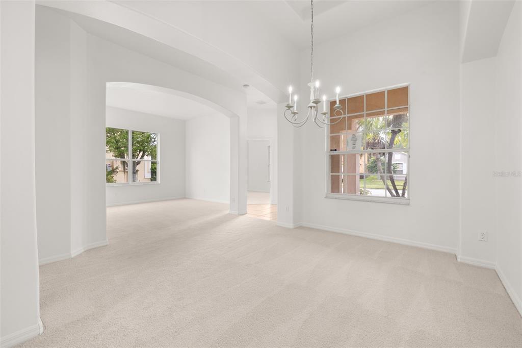 2172 The Oaks Boulevard Kissimmee, FL 34746 - Photo 15 of 81 en empty room with windows and chandelier