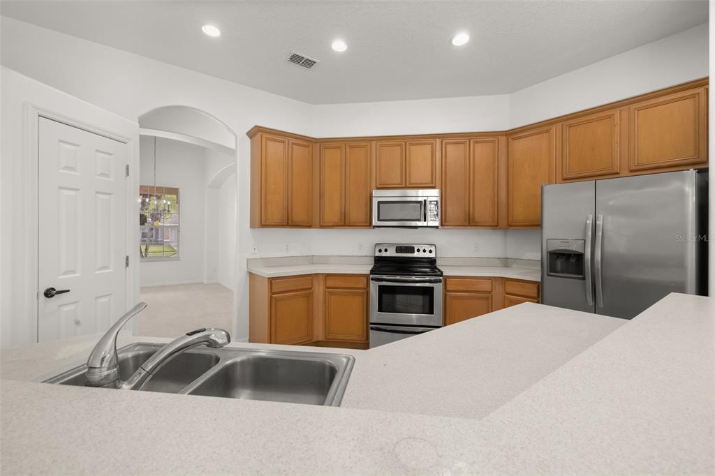 2172 The Oaks Boulevard Kissimmee, FL 34746 - Photo 22 of 81 a kitchen with kitchen island a sink appliances and cabinets