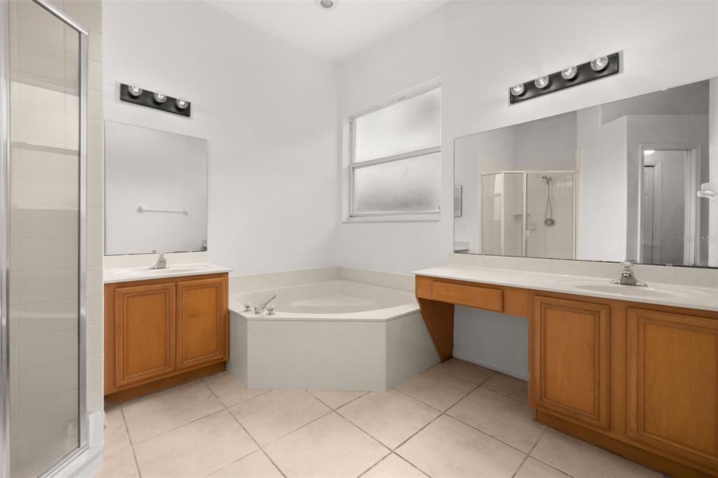 2172 The Oaks Boulevard Kissimmee, FL 34746 - Photo 37 of 81 a bathroom with a tub a sink and a mirror