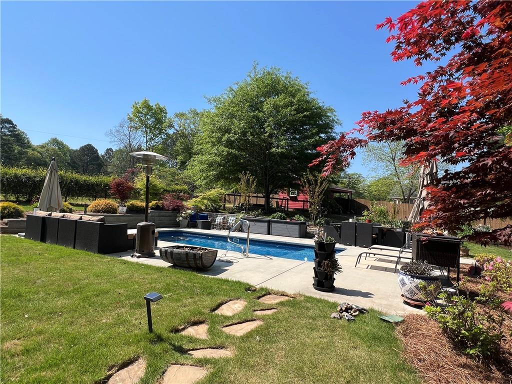 1076 Pinyan Lane Canton, GA 30115 - Photo 12 of 71 a swimming pool with outdoor seating and a garden