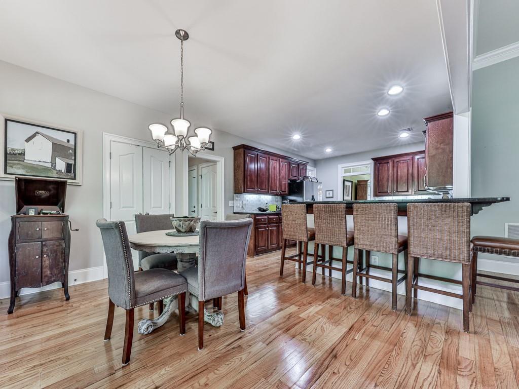 1076 Pinyan Lane Canton, GA 30115 - Photo 20 of 71 a view of a dining room with furniture a chandelier and wooden floor