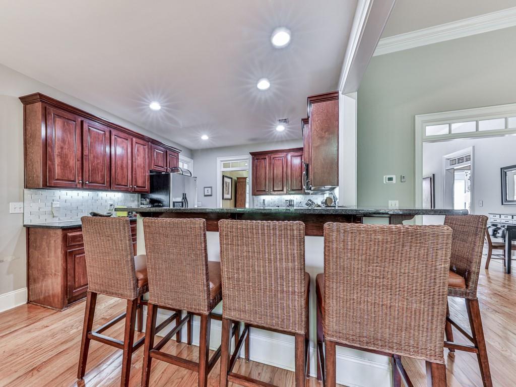 1076 Pinyan Lane Canton, GA 30115 - Photo 21 of 71 a kitchen with stainless steel appliances granite countertop a table chairs stove microwave and cabinets