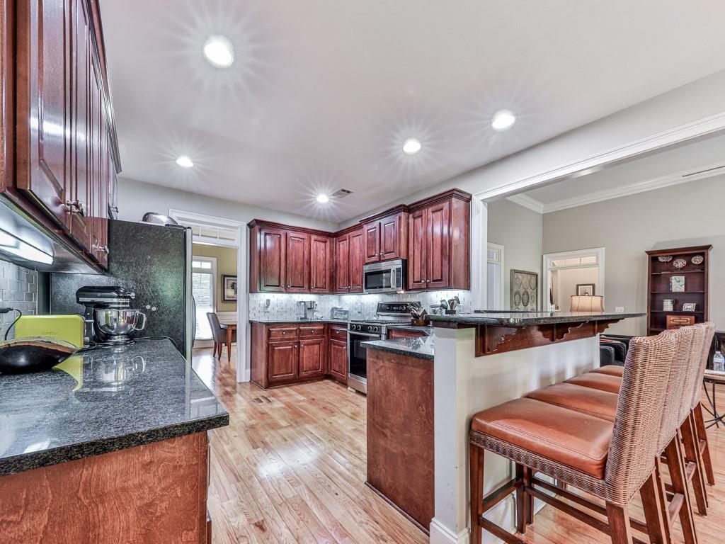 1076 Pinyan Lane Canton, GA 30115 - Photo 22 of 71 a kitchen with stainless steel appliances granite countertop sink stove top oven and cabinets