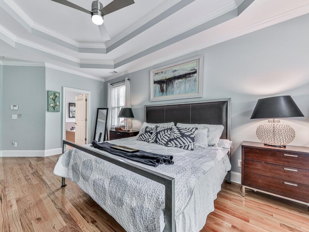 1076 Pinyan Lane Canton, GA 30115 - Photo 30 of 71 a bedroom with a large bed and a chandelier