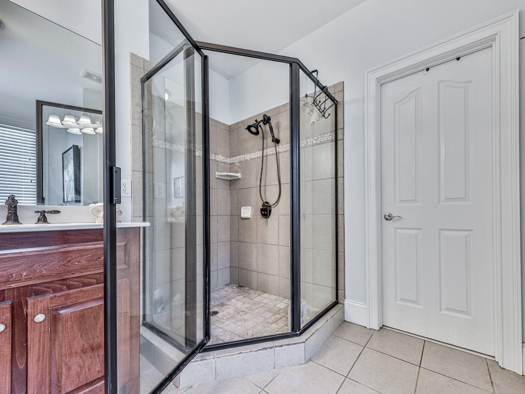 1076 Pinyan Lane Canton, GA 30115 - Photo 33 of 71 a bathroom with a glass shower door and a mirror