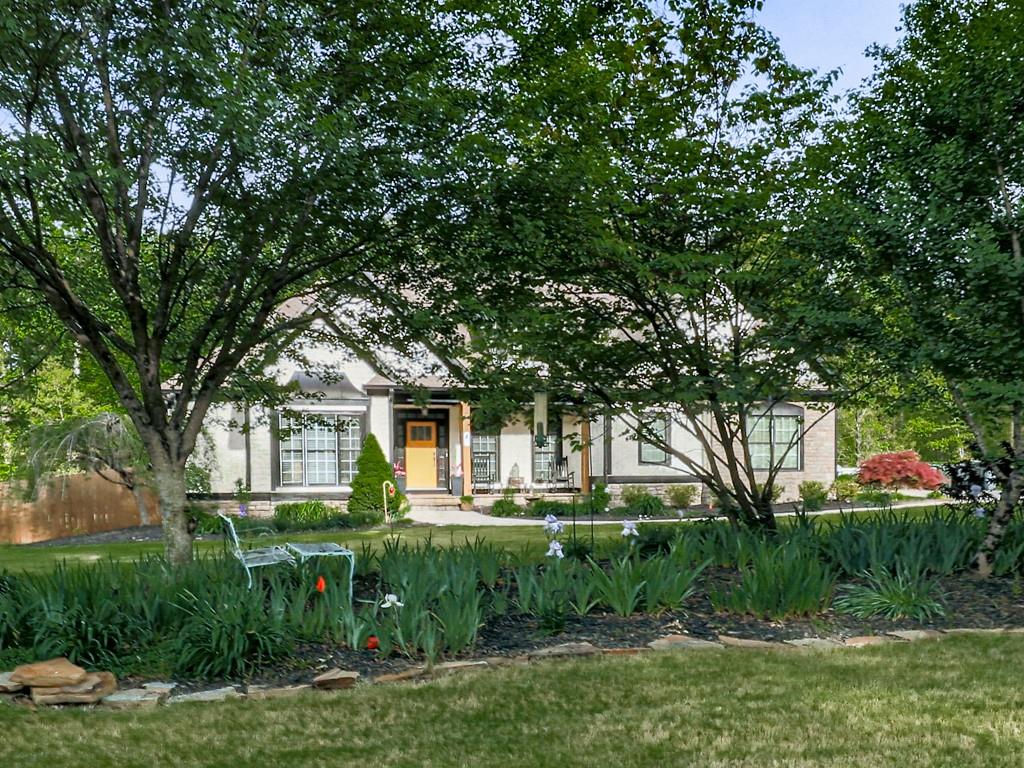 1076 Pinyan Lane Canton, GA 30115 - Photo 58 of 71 a front view of a house with a garden and trees