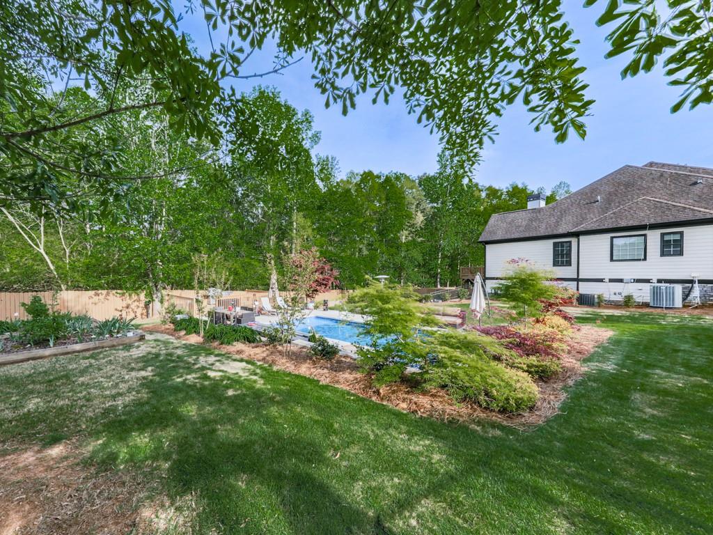 1076 Pinyan Lane Canton, GA 30115 - Photo 63 of 71 a backyard of a house with table and chairs under an umbrella