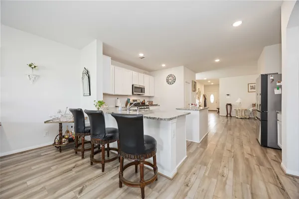 a kitchen with granite countertop a sink stove and microwave