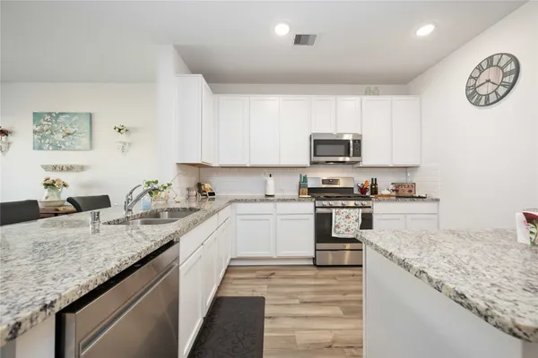 a kitchen with stainless steel appliances a refrigerator sink and microwave