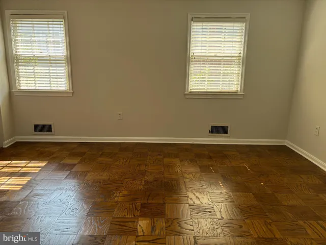 a view of a room with wooden floor and a window