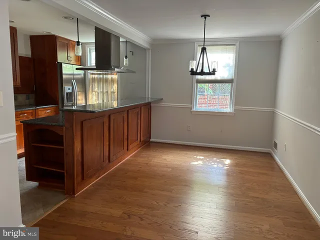 a kitchen with stainless steel appliances granite countertop a refrigerator a stove and a wooden floors