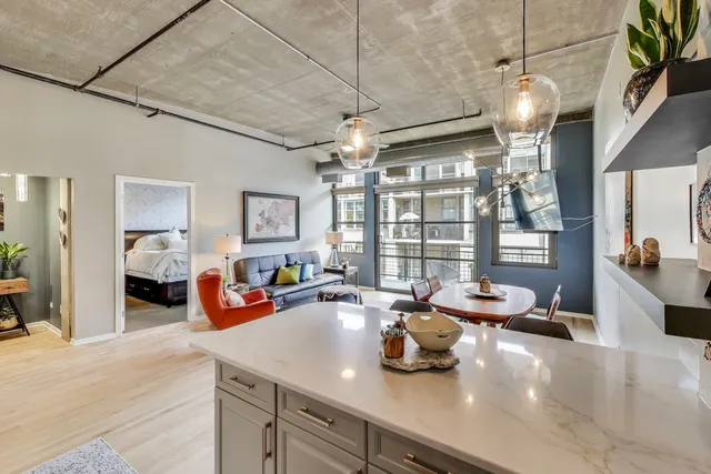 a kitchen with stainless steel appliances kitchen island granite countertop a table chairs microwave and sink