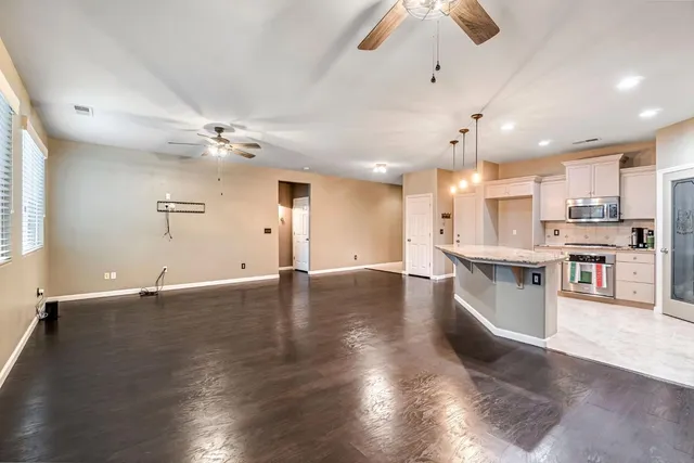 a kitchen with kitchen island a sink a stove a center island and wooden floor