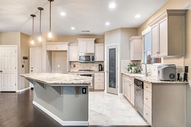 a large kitchen with granite countertop a sink and dishwasher with a large kitchen island