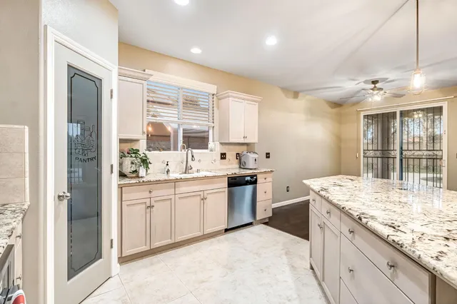 a bathroom with a granite countertop sink and a large mirror