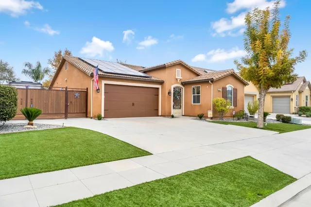 a front view of a house with a garden and yard