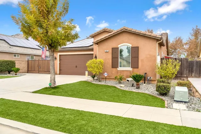 a front view of a house with a garden and yard